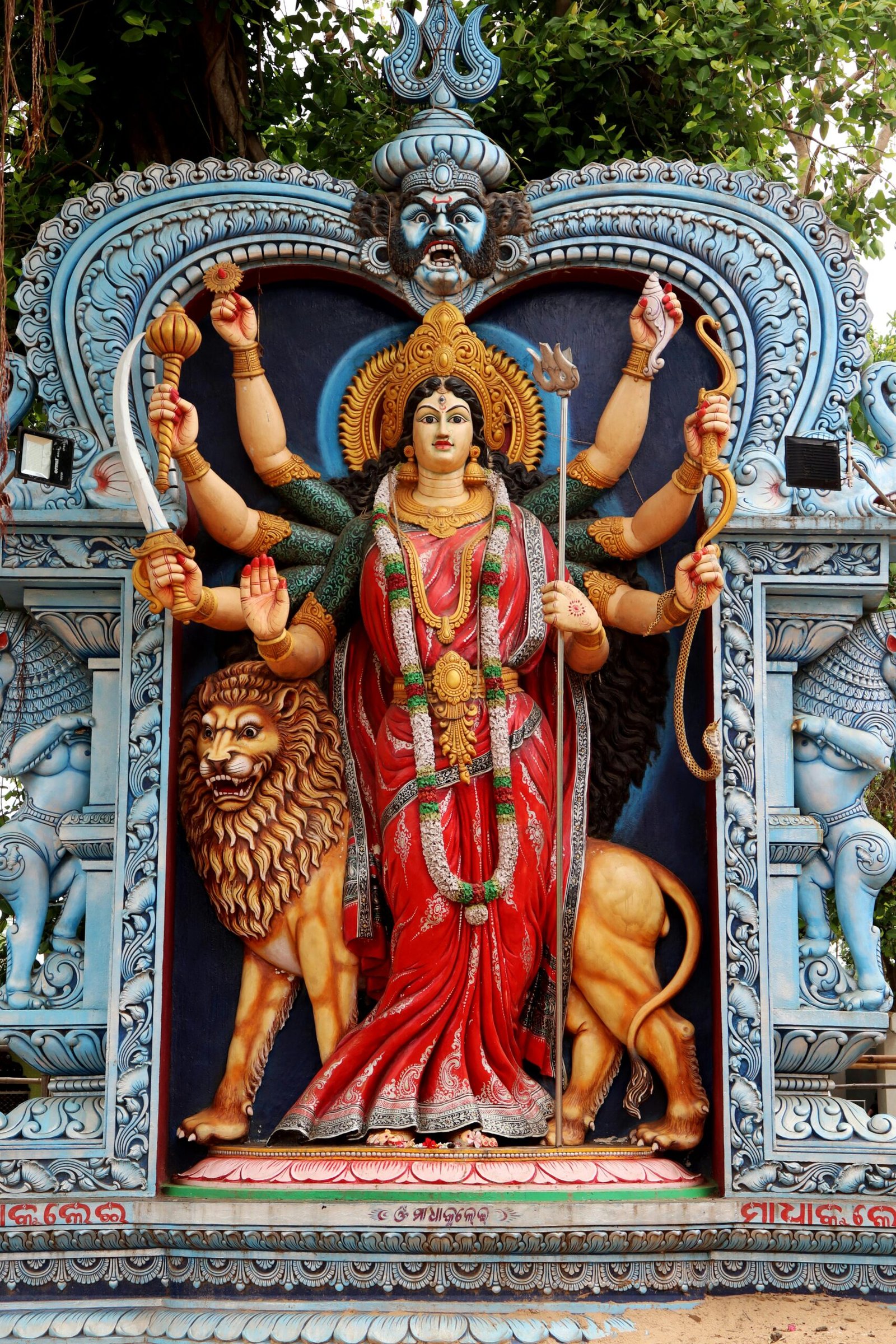 Colorful statue of a Hindu goddess with lion in Urali, India, showcasing traditional artistry.